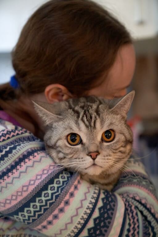 a woman holding a cat in her arms